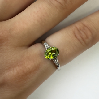 Vintage Bvlgari Peridot Diamond Ring.The central stone is an oval peridot 1.3ct with beautiful olive and light green hues with tapered diamond baguette shoulders each 0.10ct,Clarity Vs and Colour G-H.The shank is hallmarked platinum,London 1970 and signed 'BVULGARI' with serial number 38311.A beautiful ring.The ring can be resized,please contact us if you would like more information on this ring.