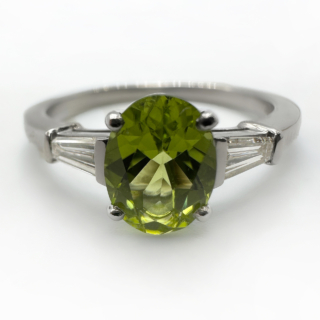 Vintage Bvlgari Peridot Diamond Ring.The central stone is an oval peridot 1.3ct with beautiful olive and light green hues with tapered diamond baguette shoulders each 0.10ct,Clarity Vs and Colour G-H.The shank is hallmarked platinum,London 1970 and signed 'BVULGARI' with serial number 38311.A beautiful ring.The ring can be resized,please contact us if you would like more information on this ring.