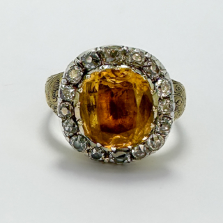 Rare Antique Georgian Golden Topaz & Old Cut Diamond Cluster Ring.Glowing golden 6ct weight topaz central stone surrounded by a halo of old cut diamonds.The cluster has a closed back in keeping with the style of the Georgian era.The stones are claw set,the shank has beautiful intricate scrolling detail additionally in keeping with the styles of jewellery in the Georgian era.An extremely beautiful period ring.Please contact us if you would like further information on this ring.
