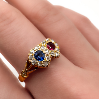 Beautiful Victorian Sapphire & Ruby Double Heart Ring.A sweet and authentic dainty 18ct yellow gold ring with a carved shank with a 1900 Birmingham hallmark.The central gems are pave set,there is a round velvet blue Ceylon sapphire and a glowing Burma ruby next to each other each with a 'heart' border of pave set old cut diamonds displaying a linked double heart.The ring is UK size L1/2 and can be resized preserving the hallmark.Please contact us if you would like to know more about this ring.