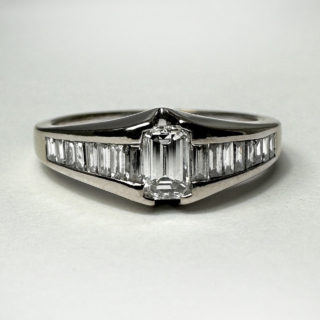 Vintage Emerald Cut Diamond Engagement Ring.Stunning 0.4ct diamond weight central diamond with baguette diamond shoulders.The central diamond is rubover set, the baguette diamonds are channel set. Hallmark Birmingham 1980's, marked 750 and 18ct. Inside the shank also has the makers mark 'JSN'. A bright sparkly elegant ring. UK size N, can be resized. Please contact us if you would like further information on this ring. This ring has a matching wedding ring which will be available, search related products or contact us.