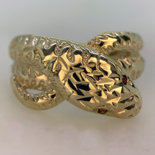 Beautiful Vintage Ruby Set and Diamond Cut Snake Ring in Hallmarked 9ct yellow Gold, Birmingham. The ring is embellished with two red ruby eyes measuring approximately 1.2 mm in diameter. The front of the shank is decorated with diamond cut detail to replicate a snakes scales, the shank tapers to the back where it is smooth polished. The width of the band is approximately 12.5 mm at the head and 2.5 mm at the back. These rings were extremely popular in the victorian era as they are a symbol of eternal love, this vintage retake of the ring is in excellent condition.
