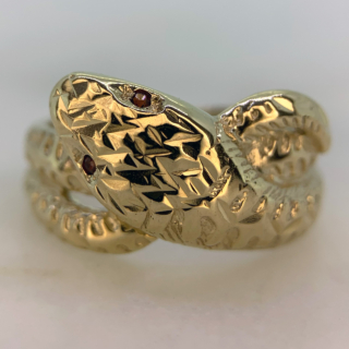 Beautiful Vintage Ruby Set and Diamond Cut Snake Ring in Hallmarked 9ct yellow Gold, Birmingham. The ring is embellished with two red ruby eyes measuring approximately 1.2 mm in diameter. The front of the shank is decorated with diamond cut detail to replicate a snakes scales, the shank tapers to the back where it is smooth polished. The width of the band is approximately 12.5 mm at the head and 2.5 mm at the back. These rings were extremely popular in the victorian era as they are a symbol of eternal love, this vintage retake of the ring is in excellent condition.