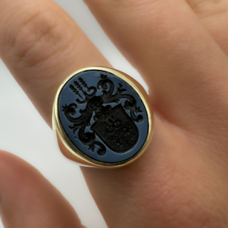 Chunky Antique Crest Intaglio Ring.A fabulous statement antique ring.The carved intaglio onto black sardonyx has a shield with ancient figures and wheat sheafs.The head of the ring is'Oxford' oval shape and measures 1.8cm x 1.4cm.The shank is chunky and weights 11.2gms.The ring can be resized.Please contact us if you would like more information on this statement ring