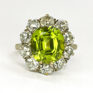 A Victorian Delicious Peridot & Old Cut Diamond Cluster Ring.Central faceted glowing olive green peridot with mid and dark green hues,measures 0.8mm diameter.The mesmerising peridot is surrounded by 10 beautiful old cut diamonds.The gems are claw set in 18ct yellow gold with an 18 ct yellow gold shank,the gallery has a pierced pattern.The head of the ring measures 1.4cm diameter.The cluster ring sits low on the finger and is comfortable to wear.Please contact us if you would like more information about this ring.This ring can be resized