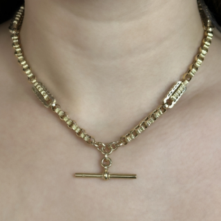 Fancy Link Antique Albert Chain Fancy Link In Yellow Gold.The chain has circular faceted links with curvy oblong links with a chased curves and stars set to the front and sides of these links. The chain measures 16.5 inches with a T-Bar drop of 1 inch. The chain has dog clip fastening and the chain has makers name 'H A & S' to the dog clip.