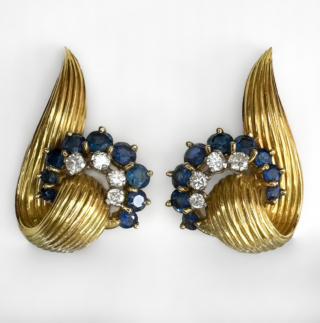 Desirable 1984 Kutchinsky Sapphire Diamond Swirl Earrings. Fully signed Kutchinsky on each earring in addition to the assay mark, 18ct. Beautifully carved rib design with a curve of midnight blue sapphires and brilliant cut diamonds. The earrings are a true designer statement in vintage earrings. Measuring 3 x 2.5 cm. The earrings are in excellent condition. Please contact us if you would like to know more about these beautiful earrings or visit us at Saddingtons Jewellery, Mayfair.