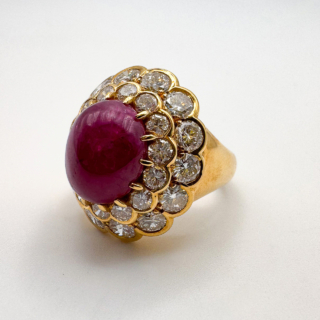 Stunning Statement Large Cabochon Ruby Diamond Cluster Ring.The central large oval 6+.ct ruby has a rich and luxurious colour and is surrounded by bright brilliant cut diamond cluster.The shank is substantial in size and is 18ct yellow gold.An exquisite and beautiful ring that sits comfortable on the finger.Please contact us if you would like more information on this beautiful ring