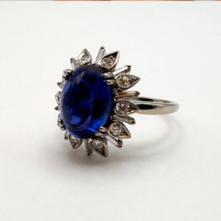 Cabochon Ceylon Sapphire Diamond Ring.Large cabochon royal blue claw set Ceylon sapphire which has gem certification,6ct weight.Stunning design with diamonds inside 'flower' petals with baguette diamond spacers.A real statement ring.A simple yet unique design.The shank is platinum with smooth curves on the mount.Please contact us if you would like to know more about this outstanding ring.