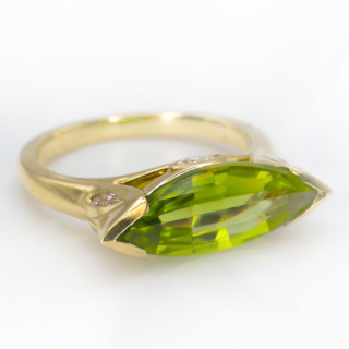 Vibrant Peridot Diamond Marquise Ring.Unusual and striking vintage Peridot ring which is the main stone.There are diamonds set in the gallery of the ring which has scrolls also.A really well designed ring in 18 ct yellow gold.If you would like to know more about this ring please message us.