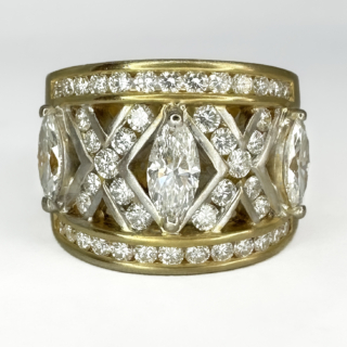 18ct 1980's Vintage Adler Diamond Ring. Adler a prestigious Swiss Jewellery house founded in 1886 showcasing Swiss craftsmanship and design. This exquisite diamond wide band ring has  3 marquise diamonds 0.5ct weight of diamond each (1.5ct total), there are round brilliant cut diamond set in an 'X' shape between each marquise diamond with a row of channel set round brilliant cut diamonds on the top and bottom of the ring 1.4ct total weight of diamonds. This brings the total content of diamonds in this ring to 2.9cts. The diamonds are Colour G-H, Clarity VS. The ring in 18ct yellow gold, the makers mark Adler in on the inside ot the ring shank. A beautiful statement ring, it sits low and comfortable on the finger. Please contact us if you would like to know more about this ring or visit us at Saddingtons Jewellery, Mayfair.