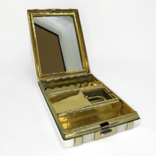 An Exceptional Early By Tiffany & Co. Patent Vanity Compact 1915-1925. The compact is crafted in sterling  silver with applied 14ct yellow gold panels and has a registered Tiffany & Co patent. The elegant rectangular compact exemplifies early Art Deco design with crisp linear geometry and beautifully proportioned gold striping to the exterior. The interior s finely gilded and retains a mirror alongside a cleverly engineered sliding internal compartment. reflection Tiffany's renowned technical innovation as much as its aesthetic excellence. Stamped "Tiffany & Co." , 14K on sterling and Patent No.722. This dates this piece cira 1915-1925. This is when Tiffany was producing some of its most refined personal luxury objects for the American and European elite. Vanity compacts of this quality, combining precious metals, patented construction and intact interior elements,are increasingly scarce and highly sought after by collectors. A timeless and highly collectible Tiffany object, equally suited to display or refined daily use. Measuring 5.8 x 4.9 x 1cm. In excellent antique condition with light wear commensurate with its age.