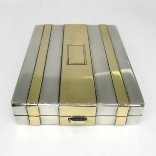 An Exceptional Early By Tiffany & Co. Patent Vanity Compact 1915-1925. The compact is crafted in sterling  silver with applied 14ct yellow gold panels and has a registered Tiffany & Co patent. The elegant rectangular compact exemplifies early Art Deco design with crisp linear geometry and beautifully proportioned gold striping to the exterior. The interior s finely gilded and retains a mirror alongside a cleverly engineered sliding internal compartment. reflection Tiffany's renowned technical innovation as much as its aesthetic excellence. Stamped "Tiffany & Co." , 14K on sterling and Patent No.722. This dates this piece cira 1915-1925. This is when Tiffany was producing some of its most refined personal luxury objects for the American and European elite. Vanity compacts of this quality, combining precious metals, patented construction and intact interior elements,are increasingly scarce and highly sought after by collectors. A timeless and highly collectible Tiffany object, equally suited to display or refined daily use. Measuring 5.8 x 4.9 x 1cm. In excellent antique condition with light wear commensurate with its age.